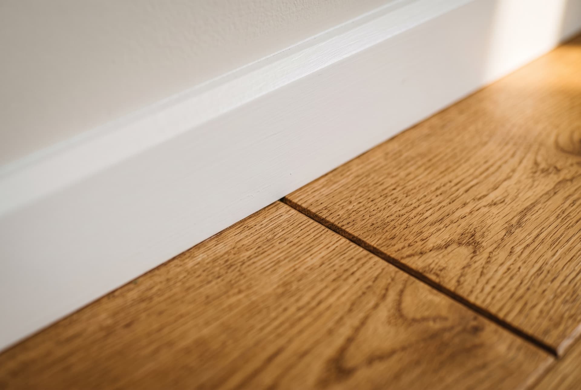 Close-up of a tight, clean join between floorboard and skirting